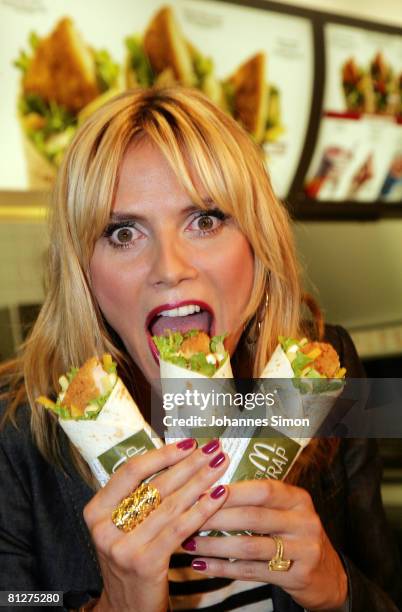 Super model Heidi Klum poses with three new designed McDonald's chicken wraps during a press conference at the Munich Inner City McDonald's...