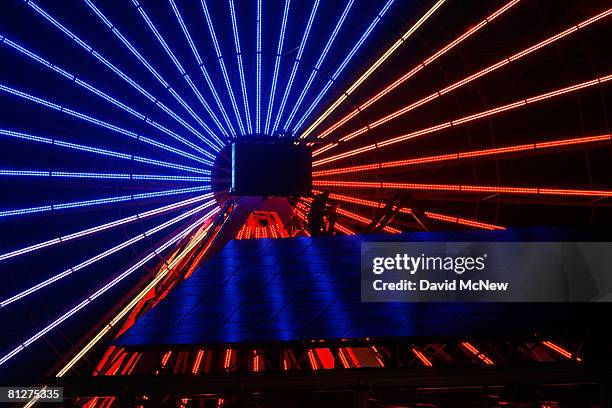 Worker is seen at the top of solar panels reflecting the lights of the spokes on the new $1.5 million solar powered Ferris wheel which replaces the...