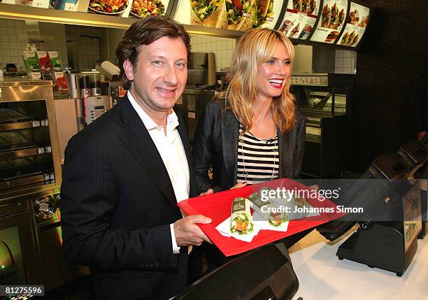 Super model Heidi Klum and Markus Pichler, head of marketing McDonald's Germany pose with three new designed McDonald's chicken wraps during a press...