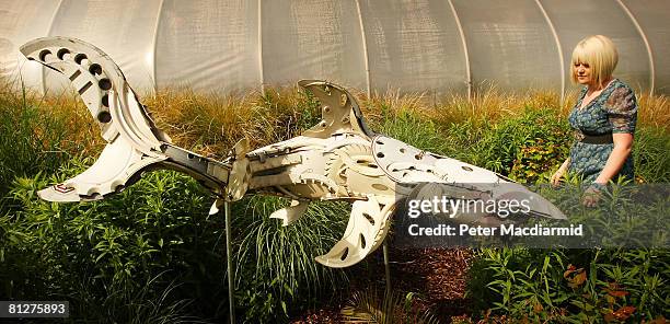 Member of staff looks at a sculpture made from hub caps entitled 'Great White' by artists Ptolemy, at the Recycled Sculpture Show at London Zoo on...