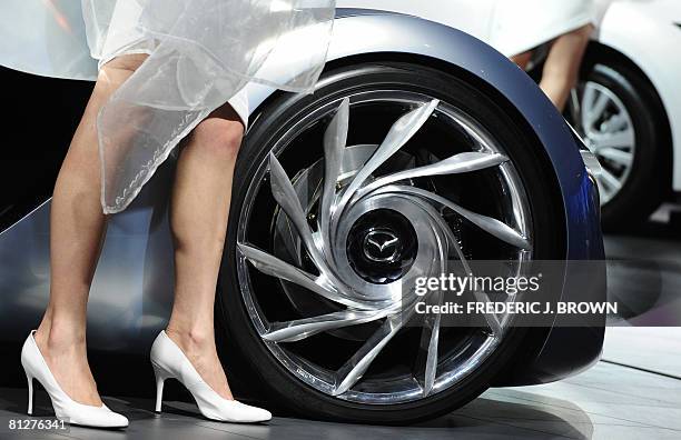 Models stand beside Mazda's concept car Taiki and Mazda 6 on display at the Beijing Auto Show on April 21, 2008. The world's top car-makers are...
