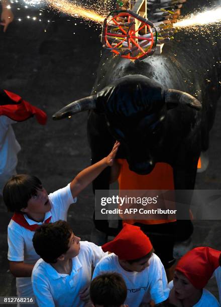 Man wearing a costume of "Toro de Fuego" chases people during the San Fermin Festival on July 11 in Pamplona, northern Spain. / AFP PHOTO / ANDER...