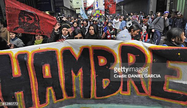 Demonstrators hold a huge banner reading "Hunger" in front of the headquarters of the Sociedad Rural Argentina during a march in support of the...