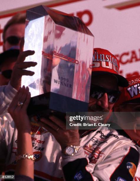 Smiling Dale Earnhardt holds his trophy after winning the Winston 500 at Talladega, Alabama October 17, 1999.