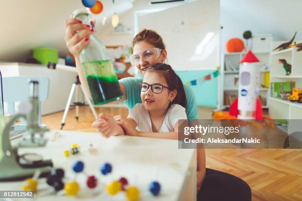 niña y su madre haciendo científico experimento - clase de quimica fotografías e imágenes de stock