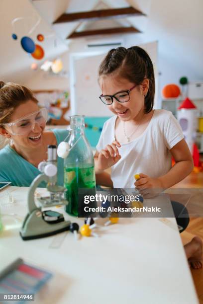 girl and her mother doing chemical experiment - school science project stock pictures, royalty-free photos & images