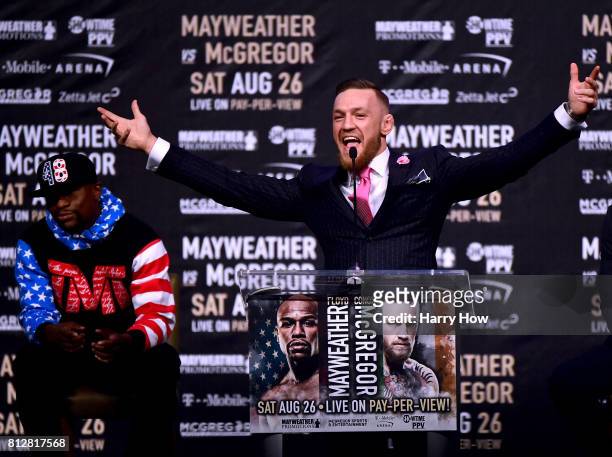 Conor McGregor speaks as Floyd Mayweather Jr. Waits in the background during the Floyd Mayweather Jr. V Conor McGregor World Press Tour at Staples...