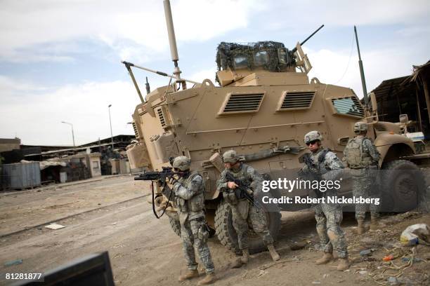 Army soldiers from the 3rd Brigade Combat Team, 4th ID, search for enemy snipers outside Jamila Market district near a 15-foot concrete wall being...