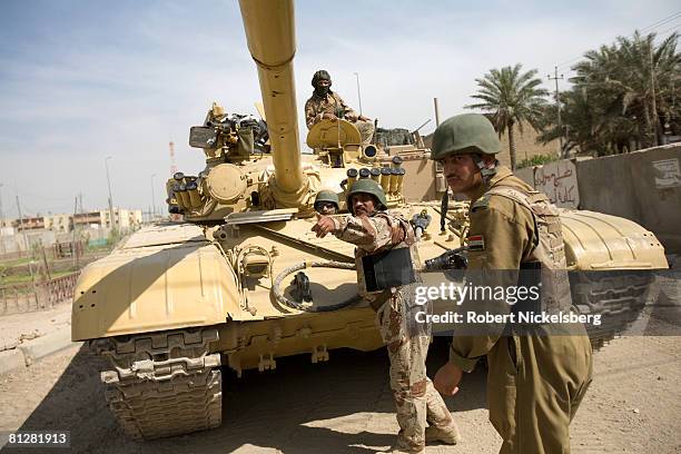 Iraqi Army officers from the 9th Division direct a Russian-made T-72 tank away from the front line concrete wall under construction in southern Sadr...