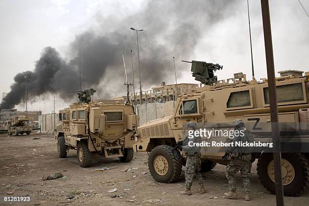 Army soldiers from the 3rd Brigade Combat Team, 4th ID take cover behind armored vehicles to an area where 15-foot concrete barriers are to be placed...