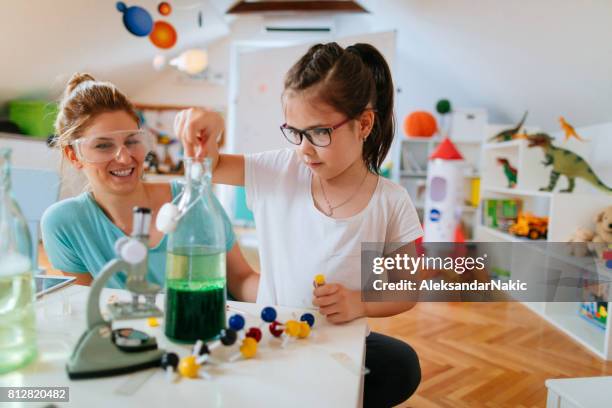 la ragazza e sua madre fanno esperimenti scientifici - ricerca di scienze foto e immagini stock