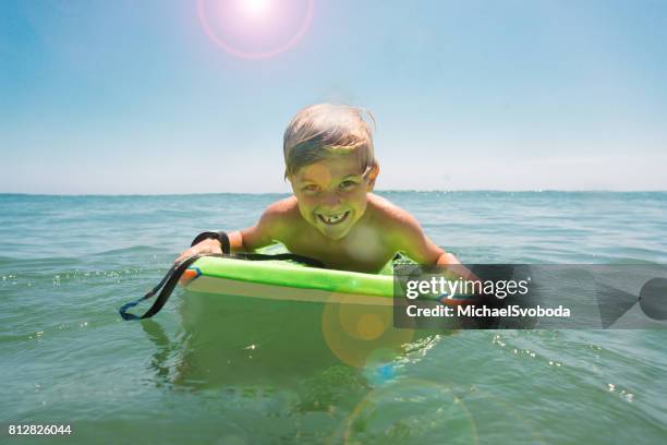 jongen met plezier in de oceaan - hobbie stockfoto's en -beelden