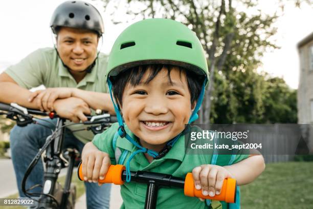 father and son on bikes - sports helmet stock pictures, royalty-free photos & images