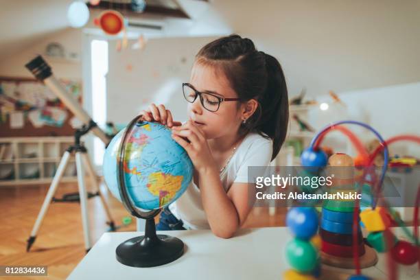 fille regardant globe - physical geography stock photos et images de collection