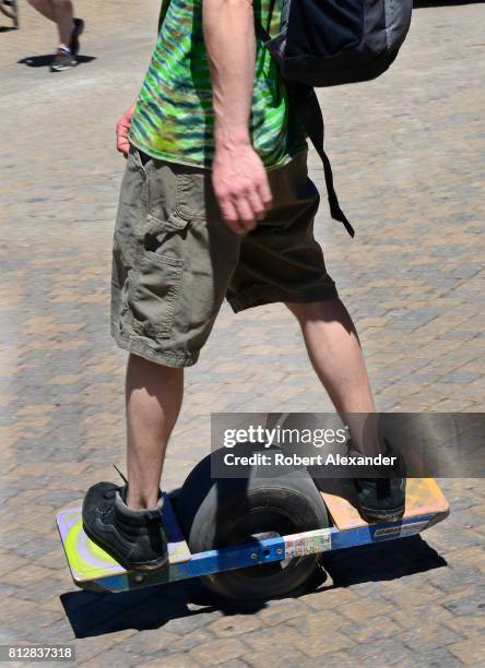Young man rides his Onewheel electric skateboard in Vail, Colorado.