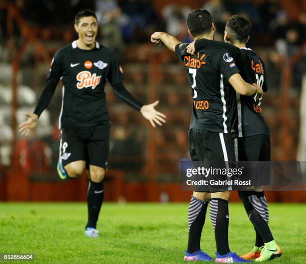 Santiago Salcedo of Libertad celebrates with teammates Oscar Cardozo and Jesus Medina after scoring the third goal of his team during a first leg...