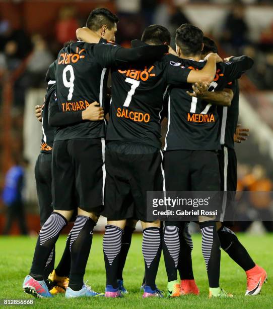 Santiago Salcedo of Libertad celebrates with teammates Oscar Cardozo and Jesus Medina after scoring the third goal of his team during a first leg...