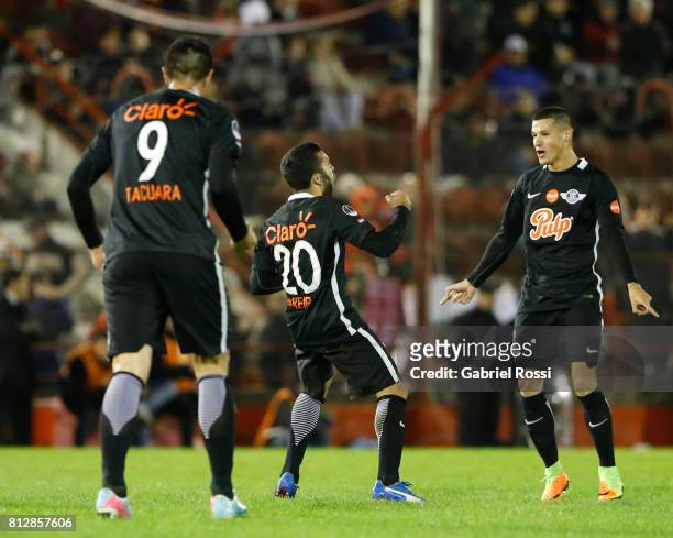 Antonio Bareiro of Libertad celebrates with teammates Oscar Cardozo and Alan Benitez after scoring the fourth goal of his team during a first leg...