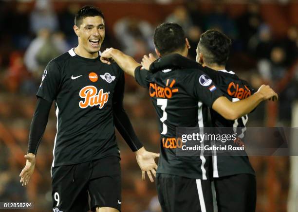 Santiago Salcedo of Libertad celebrates with teammates Oscar Cardozo and Jesus Medina after scoring the third goal of his team during a first leg...