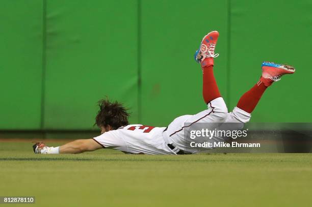 Bryce Harper of the Washington Nationals and the National League catches a ball hit by Salvador Perez of the Kansas City Royals and the American...
