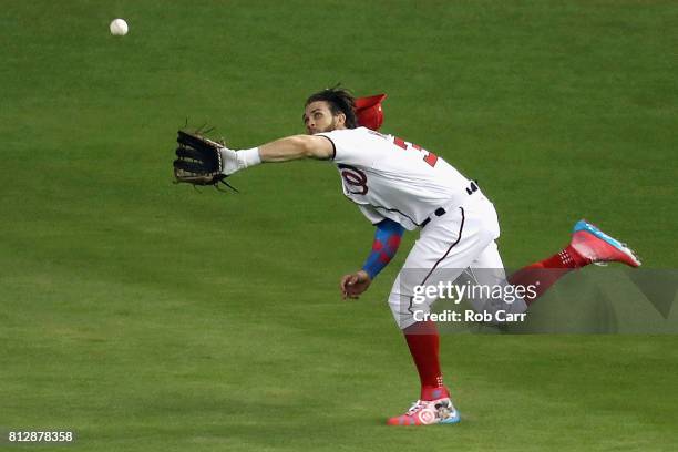 Bryce Harper of the Washington Nationals and the National League catches a ball hit by Salvador Perez of the Kansas City Royals and the American...