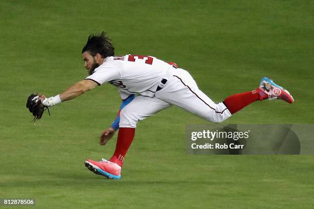 Bryce Harper of the Washington Nationals and the National League catches a ball hit by Salvador Perez of the Kansas City Royals and the American...