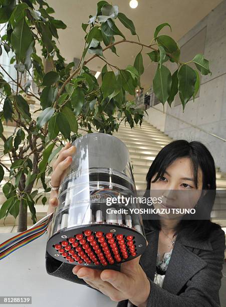 Tokyo University postgraduate student Rika Ito displays a device capable of translating the variations between light and shadows into vibrations...