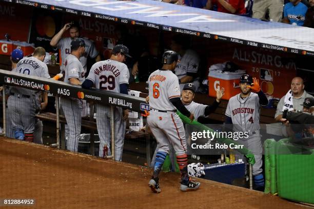 Jonathan Schoop of the Baltimore Orioles and the American League returns to the dugout after scoring a run on an RBI single by Miguel Sano of the...