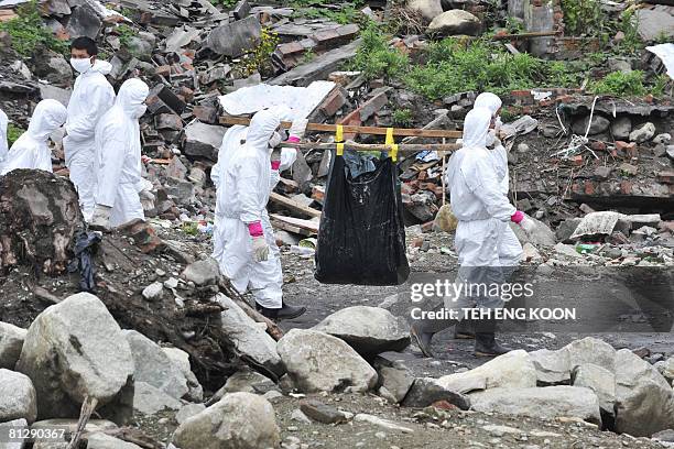 Chinese soldiers dressed in protective suits carry a dead body in Yingxiu town of the Wenchuan county, in China's southwestern province of Sichuan on...