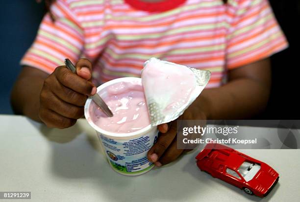 Child opens a joghurt at the Wuppertal Tafel on May 30, 2008 in Wuppertal-Barmen, Germany. Unicef, United Nation's Children's Fund reports an...