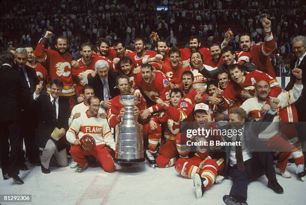 Team portrait of the players and staff of the Calgary Flames as they pose on the ice with the Stanley Cup trophy after they defeated the Montreal...