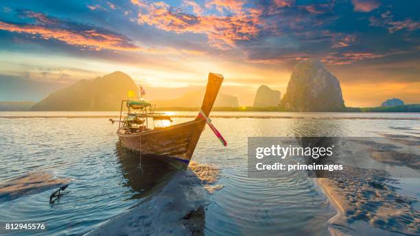 tropical magnifique coucher de soleil sur la mer avec bateau à longue queue au sud de la thaïlande - phuket photos et images de collection