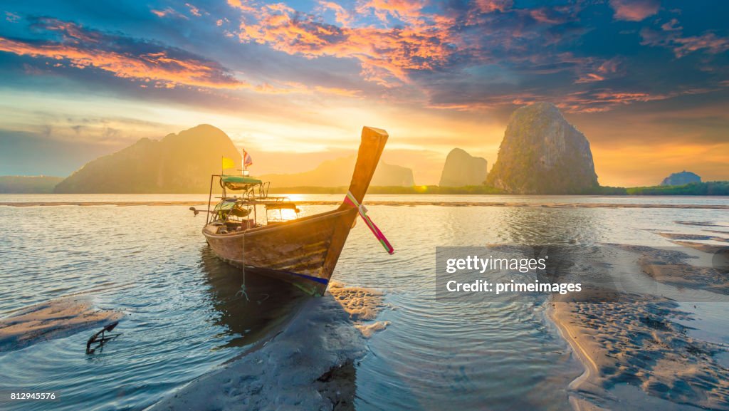 Bellissimo tramonto sul mare tropicale con barca a coda lunga nel sud della Thailandia