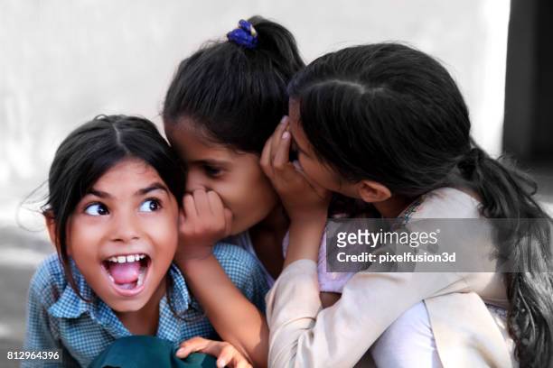 vrolijke kinderen in oor fluisteren - foundation conversations story of a girl stockfoto's en -beelden