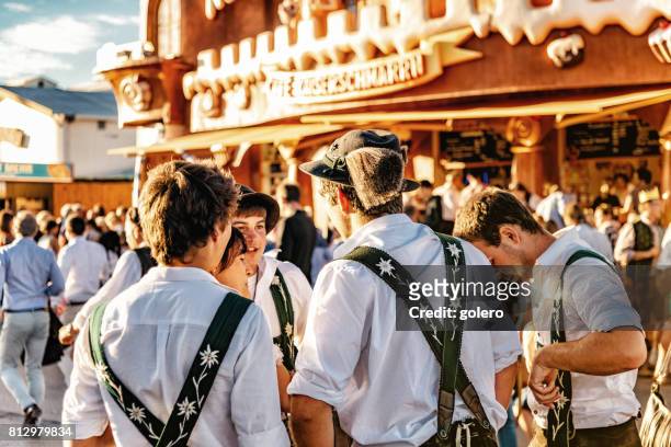 junger mann im bayerischen kleiden auf dem oktoberfest in münchen - oktoberfest stock-fotos und bilder