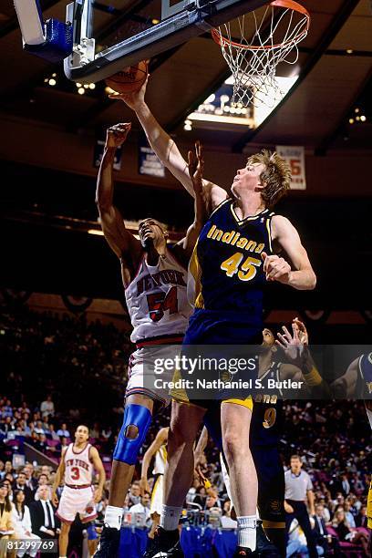 Rick Smits of the Indiana Pacers grabs the rebound against Charles Smith of the New York Knicks in Game Five of the Eastern Conference Finals during...