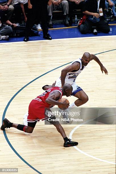 Michael Jordan of the Chicago Bulls dribbles past Bryon Russell of the Utah Jazz prior to hitting the game winning jumpshot during game six of the...