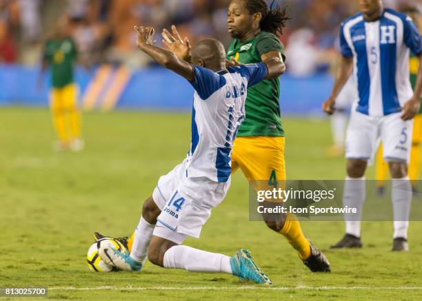 Honduras midfielder Oscar Boniek Garcia slides to win the ball from French Guiana forward Rhudy Evens during the CONCACAF Gold Cup Group A match...