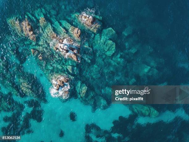 lonely boat near reefs - island aerial stock pictures, royalty-free photos & images