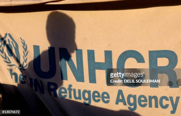 Displaced Syrian child, who fled the countryside surrounding the Islamic State group's Syrian stronghold of Raqa, is seen silhouetted on a UNHCR tent...