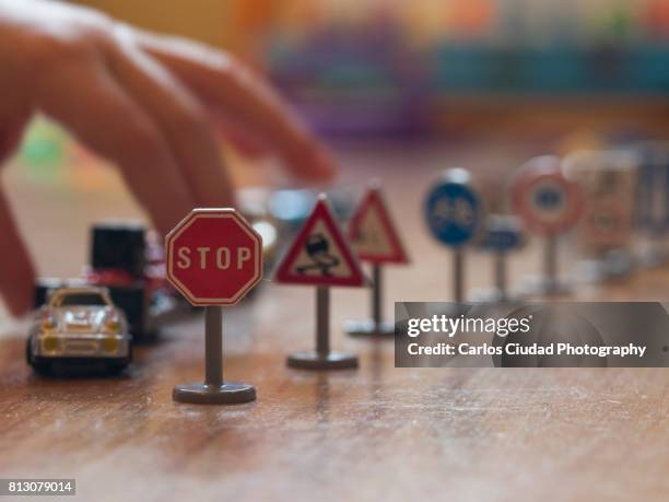 child playing with toy cars and traffic signals on wooden floor - caution sign traffic stockfoto's en -beelden