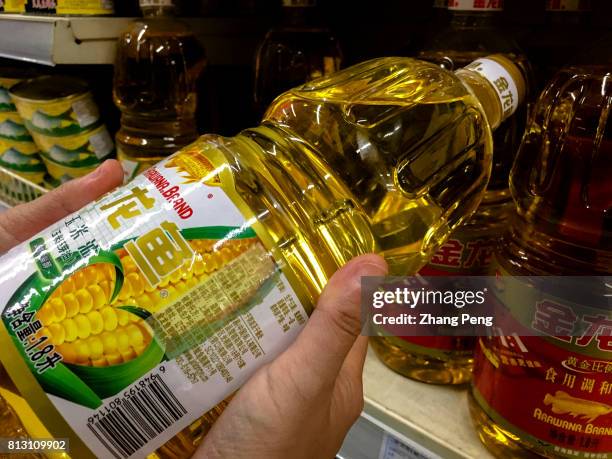 Customer is choosing a corn oil product of Arawana brand in a Chinese supermarket. Arawana, is a grain and oil brands held by Wilmar International...