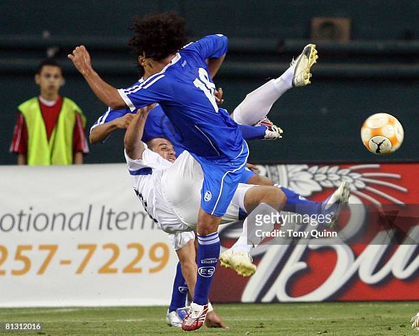 Maynor Morales of Guatemala flips over while kicking the ball away from Alexander Escobar of El Salvador during an international friendly match on...