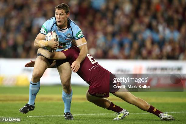 Joshua Jackson of the Blues is tackled during game three of the State Of Origin series between the Queensland Maroons and the New South Wales Blues...