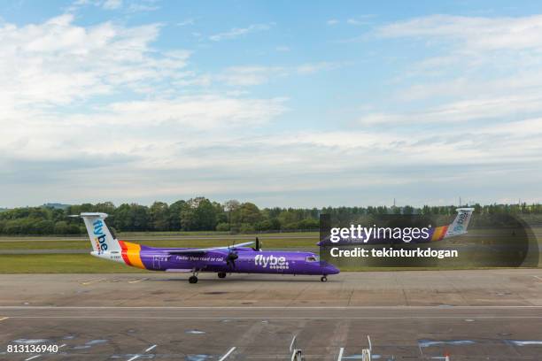 aviones listos para despegar en la pista del aeropuerto de edimburgo en escocia inglaterra reino unido - flybe fotografías e imágenes de stock