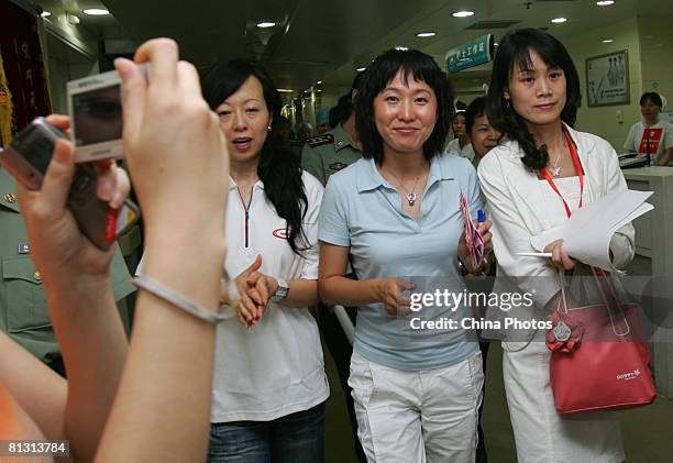 Chinese Olympic champion long-distance runner Wang Junxia arrives at the Xijing Hospital to meet injured earthquake survivors transfered from quake...