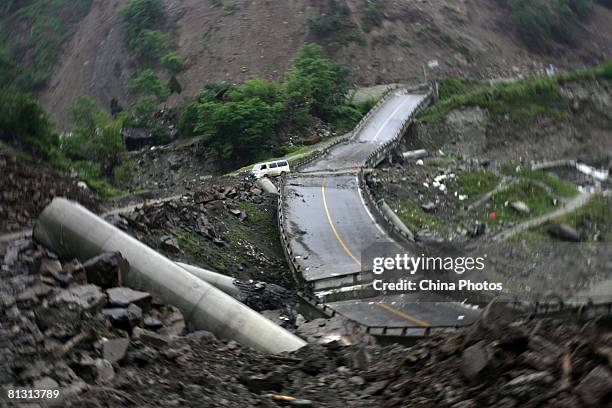 Van is parked by a bridge destroyed by a landslide caused by an earthquake on a road leading to the Yingxiu Township May 29, 2008 in Wenchuan County...