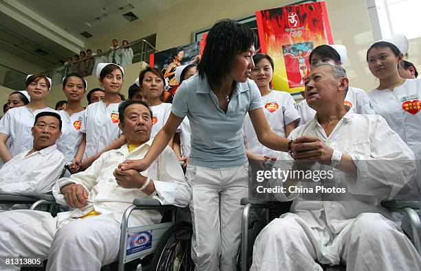 Chinese Olympic champion, long-distance runner Wang Junxia talks with injured earthquake survivors transfered from quake areas in Sichuan Province at...