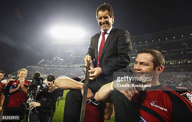 Retiring coach Robbie Deans is lifted by his players as he salutes the crowd with the Crusaders sword following the Crusaders win over the Waratahs...