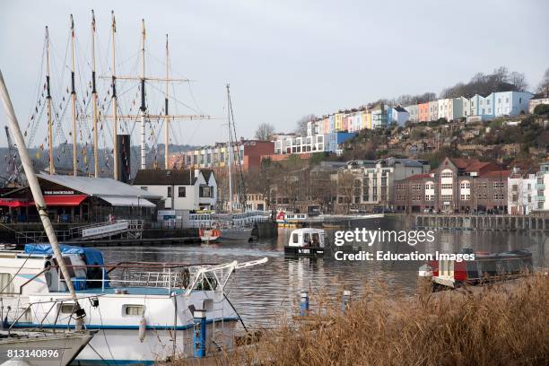 Colorful houses overlook a pedestrian ferry crossing the floating harbor in Bristol Avon England UK.